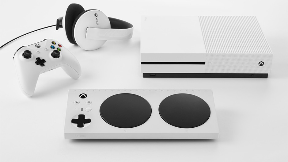 The Xbox Adaptive Controller, next to an xbox s, headphones, and controller.